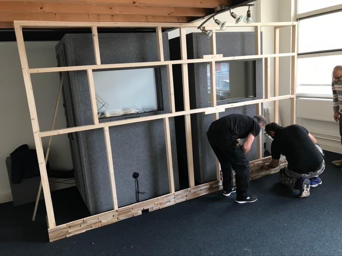 Twee mannen bouwen de houten wand om de studiobooths in Utrecht